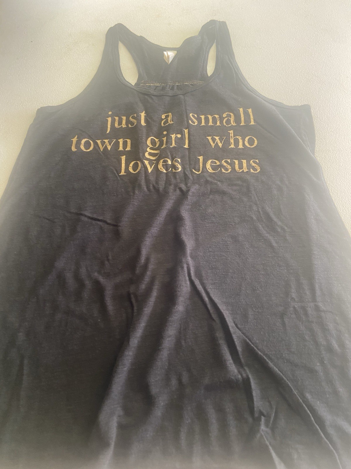 Black Racerback Tank top with a pleated back with gold “Just a Small Town…”
