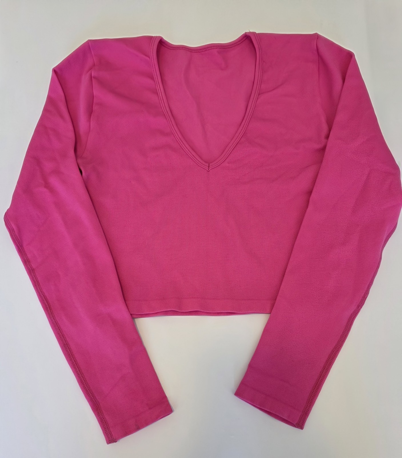 Hot pink long sleeve cropped nylon/spandex v neck top. Size S.New without tags.